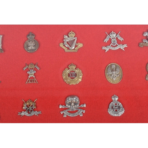 476 - TWO LARGE FRAMED AND GLAZED SETS OF MILITARY CAP BADGES, the badges cover different eras and include... 