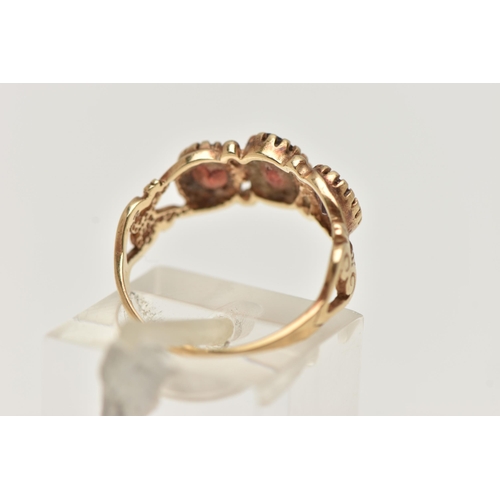 18 - A 9CT GOLD GARNET RING, designed as three graduated oval garnets in claw settings to the scrolling s... 