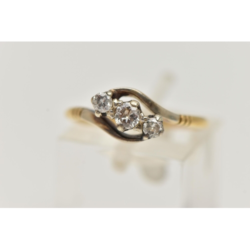 22 - A THREE STONE CROSSOVER DIAMOND RING, designed as a diagonal line of three brilliant cut diamonds in... 