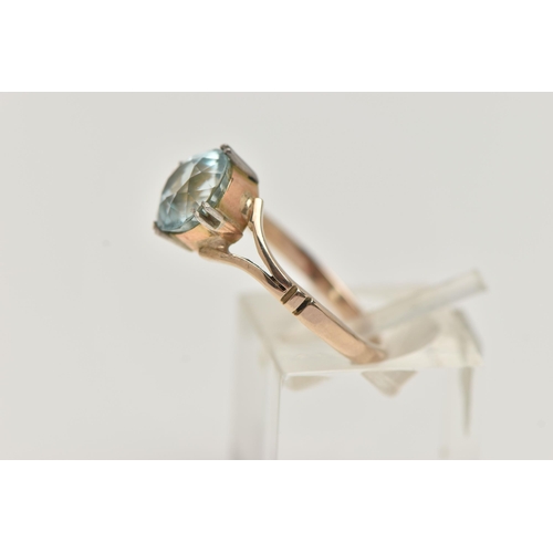 23 - AN AQUAMARINE RING, designed as a circular cut aquamarine in a double four claw setting to the bifur... 