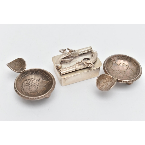 42 - A WHITE METAL SNUFF BOX AND TWO ASHTRAYS, rectangular box featuring two Flintlocks to the hinged cov... 