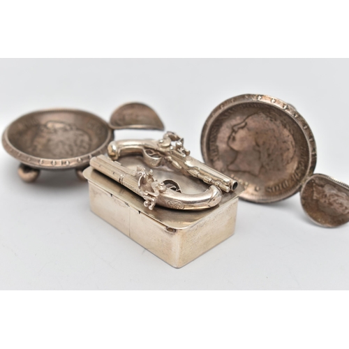 42 - A WHITE METAL SNUFF BOX AND TWO ASHTRAYS, rectangular box featuring two Flintlocks to the hinged cov... 