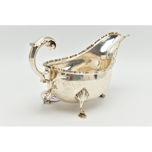 113 - AN ELIZABETH II SILVER SAUCE BOAT, a scalloped edge sauce boat with three hooved feet, hallmarked 'T... 