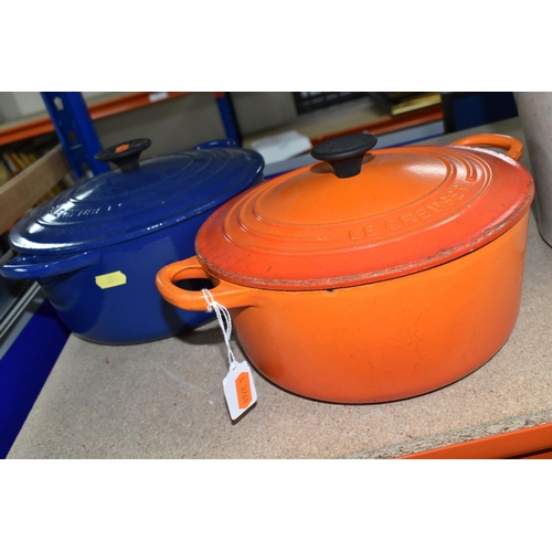 354 - TWO LE CREUSET CASSEROLE DISHES, comprising a Volcanic orange 22cm dish and a deep blue 24cm example... 