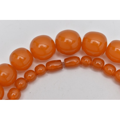 1244A - TWO EARLY TO MID 20TH CENTURY BAKELITE BEAD NECKLACES, the first a single row of circular orange bea... 