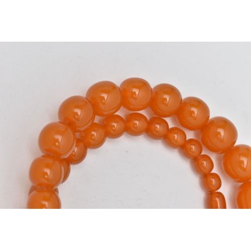 1244A - TWO EARLY TO MID 20TH CENTURY BAKELITE BEAD NECKLACES, the first a single row of circular orange bea... 