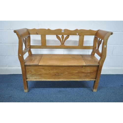 1248 - A 19TH CENTURY STYLE PINE HALL SETTLE, with foliate detail to back and sides and a single hinged sea... 