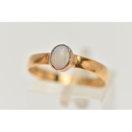15 - AN OPAL YELLOW METAL SINGLE STONE RING, set with an oval opal cabochon, within a milgrain setting, t... 