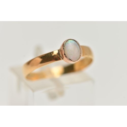 15 - AN OPAL YELLOW METAL SINGLE STONE RING, set with an oval opal cabochon, within a milgrain setting, t... 