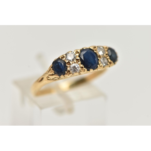 32 - A YELLOW METAL SAPPHIRE AND DIAMOND RING, set with three oval cut deep blue sapphires, interspaced w... 
