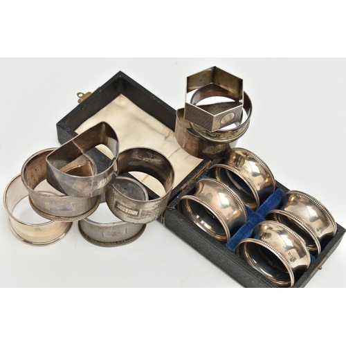 135 - AN ASSORTMENT OF SILVER NAPKIN RINGS, to include a cased set of four napkin rings with bead detail, ... 
