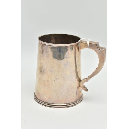 136 - A MID 20TH CENTURY SILVER TANKARD, polished tapered form fitted with a scroll handle, approximate he... 