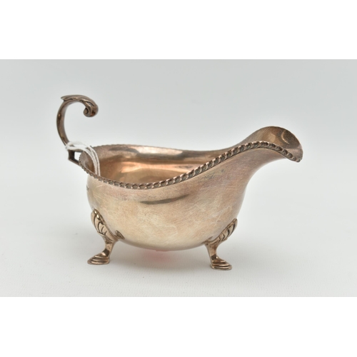 137 - A MID 20TH CENTURY SILVER GRAVY BOAT, polished form, gadrooned rim, fitted with a scroll handle, rai... 