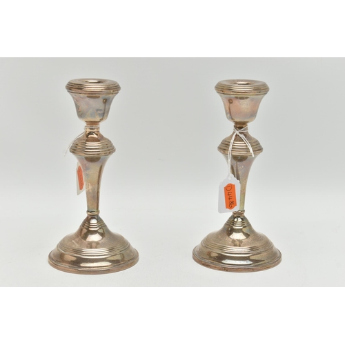 146 - A PAIR OF SILVER CANDLE STICK HOLDERS, tapered polished form, on round weighted bases, approximate h... 