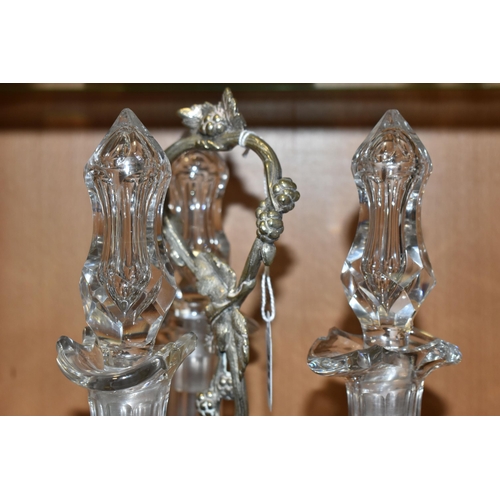 357 - THREE LATE NINETEENTH CENTURY DECANTERS ON A PLATED STAND, the footed stand with foliate decoration,... 