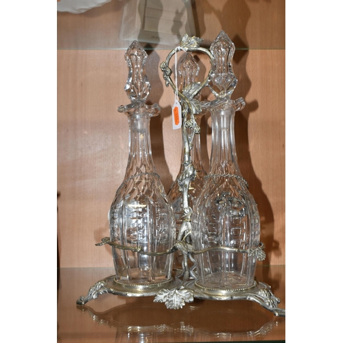 357 - THREE LATE NINETEENTH CENTURY DECANTERS ON A PLATED STAND, the footed stand with foliate decoration,... 