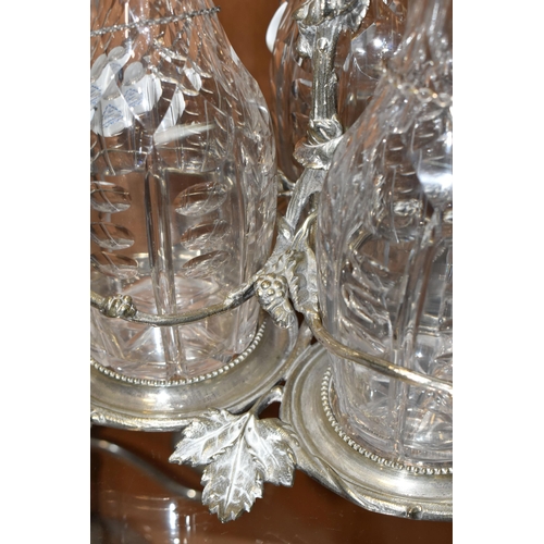 357 - THREE LATE NINETEENTH CENTURY DECANTERS ON A PLATED STAND, the footed stand with foliate decoration,... 