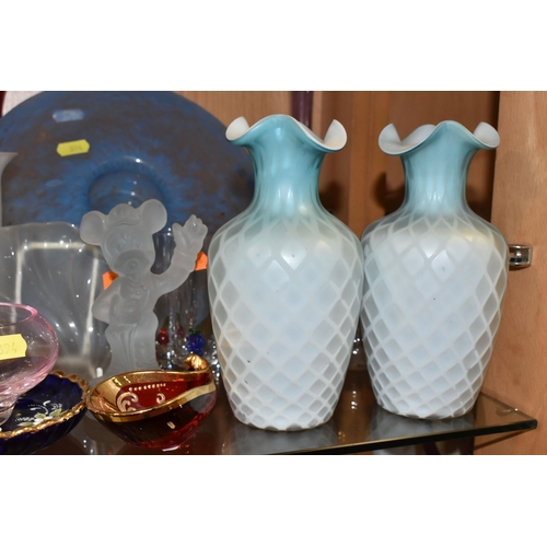 394 - A COLLECTION OF COLOURED GLASSWARE, comprising two pale blue satin quilted air - trap vases, height ... 