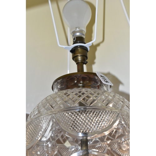 415 - A CUT CRYSTAL TABLE LAMP, with bronzed effect base and cream shade, height to top of bulb fitting 48... 