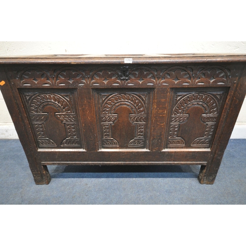 1203 - A GEORGIAN OAK COFFER, the hinged lid enclosing a candle box, three carved front panels, width 118cm... 