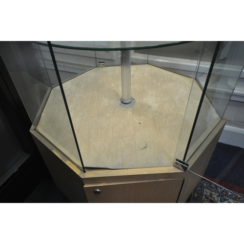 1208 - A RIPPLE TALL GLASS OCTAGONAL DISPLAY CABINET, the two opposing doors, enclosing three circular revo... 