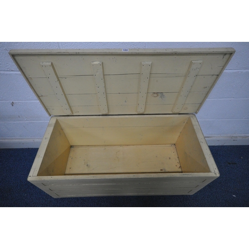 1261 - A CREAM PAINTED WOODEN TOOL CHEST, with a hinged lid, on castors, width 113cm x depth 49cm x height ... 