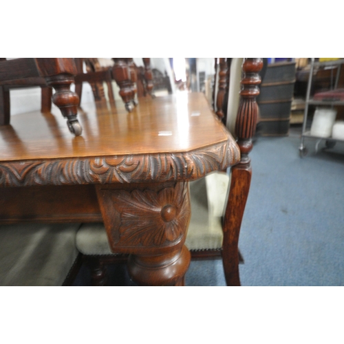 1270 - AN EDWARDIAN OAK WIND OUT DINING TABLE, with canted corners, turned and fluted legs, on ceramic cast... 