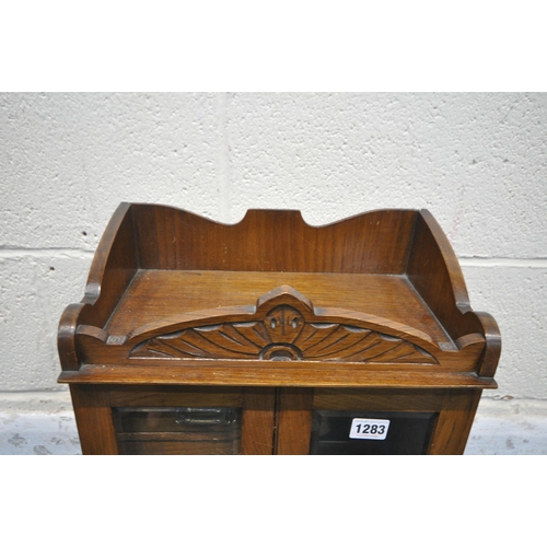 1283 - A 20TH CENTURY OAK SMOKERS CABINET, with raised top section, two bevelled glass doors enclosing thre... 