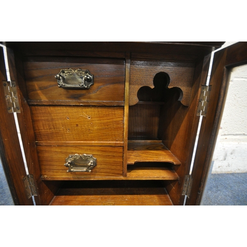 1283 - A 20TH CENTURY OAK SMOKERS CABINET, with raised top section, two bevelled glass doors enclosing thre... 