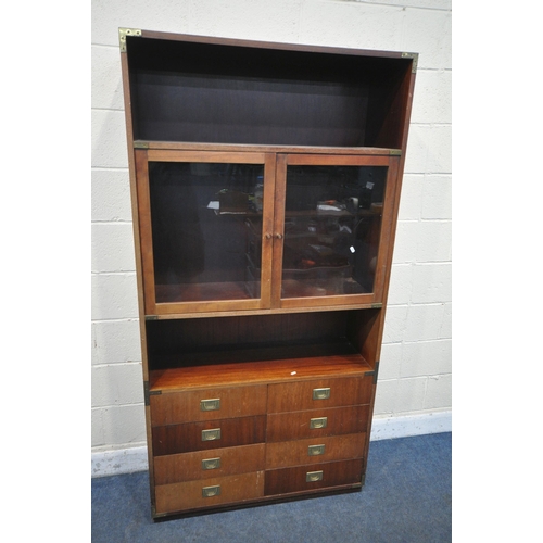 1341 - A MODERN MAHOGANY CAMPAIGN BOOKCASE, with two glazed doors and eight drawers, width 101cm x depth 36... 