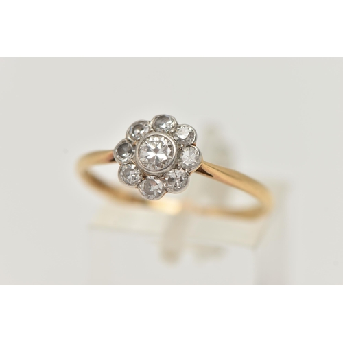 12 - A DIAMOND CLUSTER RING, a principally set round brilliant cut diamond, bezel set in white metal, set... 