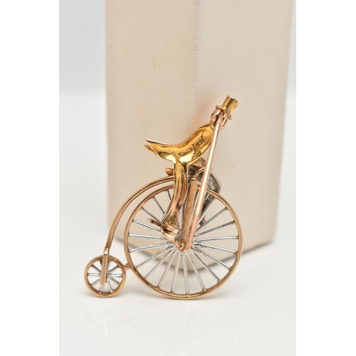 44 - A 9CT GOLD PENNY FARTHING BROOCH, a white and yellow gold gentleman riding a penny farthing bicycle,... 