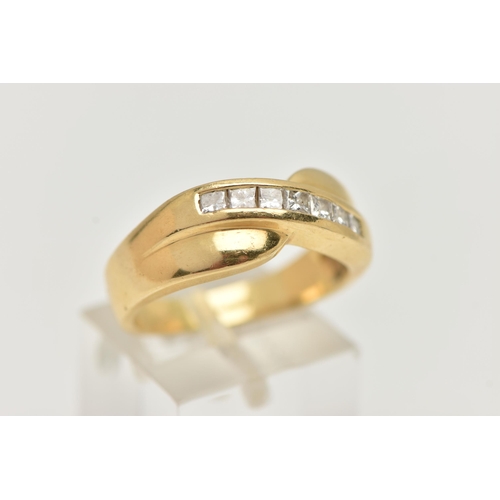 59 - AN 18CT GOLD DIAMOND SET RING, seven princess cut diamonds channel set in yellow gold, cross over mo... 