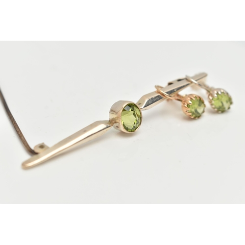 63 - A PERIDOT BAR BROOCH AND EARRINGS, an oval cut peridot collet set in yellow metal with milgran detai... 