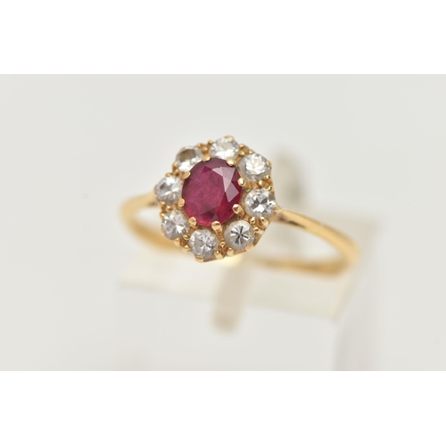 69 - A YELLOW METAL RUBY AND DIAMOND CLUSTER RING, of a circular form, set with a central circular cut ru... 