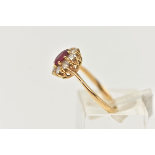 69 - A YELLOW METAL RUBY AND DIAMOND CLUSTER RING, of a circular form, set with a central circular cut ru... 