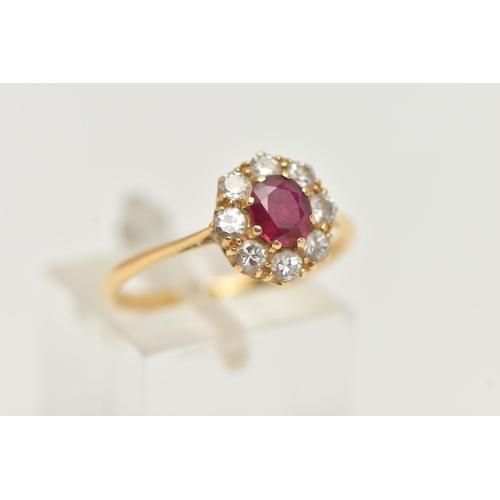 69 - A YELLOW METAL RUBY AND DIAMOND CLUSTER RING, of a circular form, set with a central circular cut ru... 