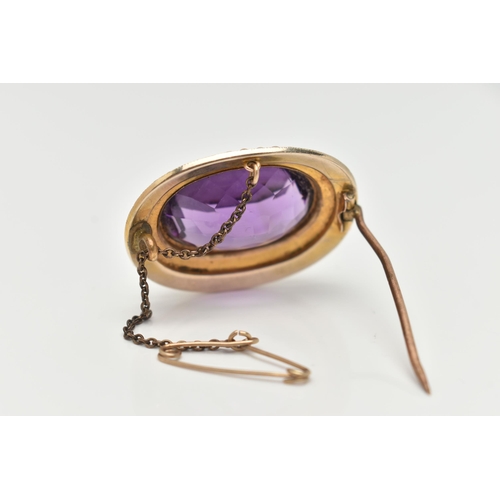 76 - A YELLOW METAL GEM AND ENAMEL BROOCH, of an oval form, set with a large oval cut amethyst, within a ... 