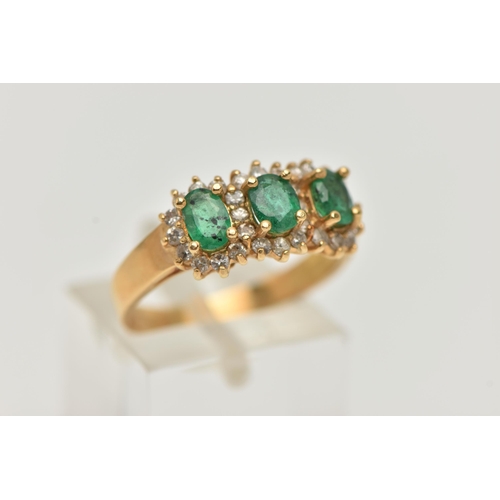 98 - AN 18CT GOLD EMERALD AND DIAMOND RING, designed as three claw set, oval cut emeralds, heavily includ... 