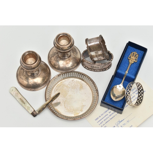 141 - A SELECTION OF SILVERWARE, to include a pair of dwarf candlesticks, a pair of napkin rings, a limite... 