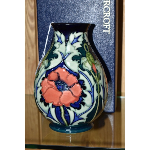 333 - A BOXED MOORCROFT POTTERY 'POPPY' BALUSTER VASE, decorated with tube lined poppies on a dark blue-gr... 