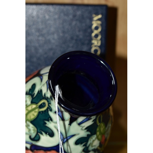 333 - A BOXED MOORCROFT POTTERY 'POPPY' BALUSTER VASE, decorated with tube lined poppies on a dark blue-gr... 