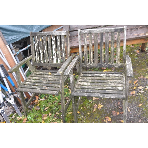 1009 - A PAIR OF WEATHERED TEAK GARDEN ARMCHAIRS, along with a selection of garden tools, including three s... 