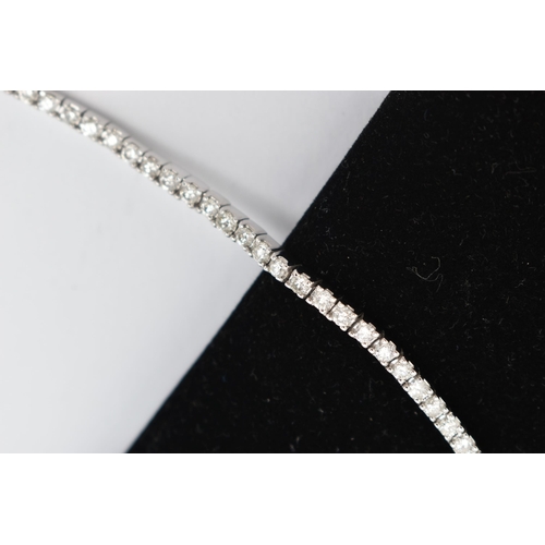 23 - A 9CT WHITE GOLD DIAMOND LINE BRACELET, designed as sixty-four round brilliant cut diamonds each wit... 