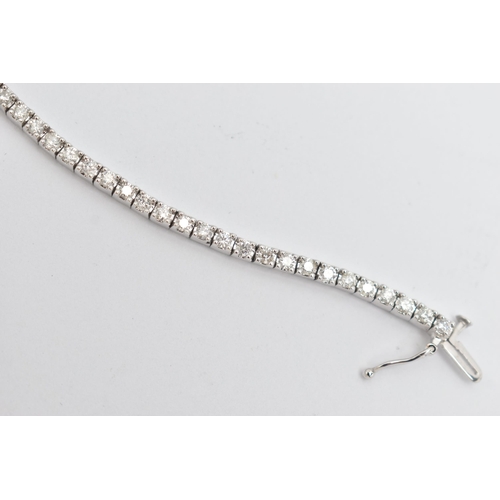 23 - A 9CT WHITE GOLD DIAMOND LINE BRACELET, designed as sixty-four round brilliant cut diamonds each wit... 