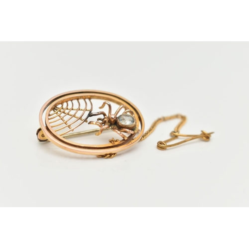 63 - AN EARLY 20TH CENTURY SPIDER BROOCH, of an oval outline, featuring an open work spider web design an... 