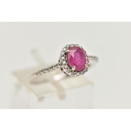 71 - AN 18CT WHITE GOLD RUBY AND DIAMOND RING, set with an oval cut ruby, in a halo of round brilliant cu... 