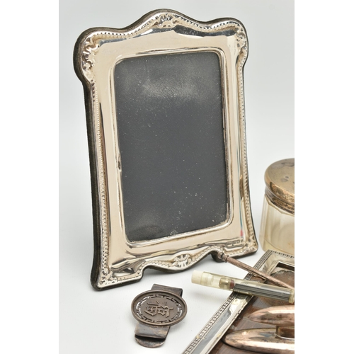 137 - A SMALL PARCEL OF SILVER, comprising an Elizabeth II easel back photograph frame, inner dimensions 1... 