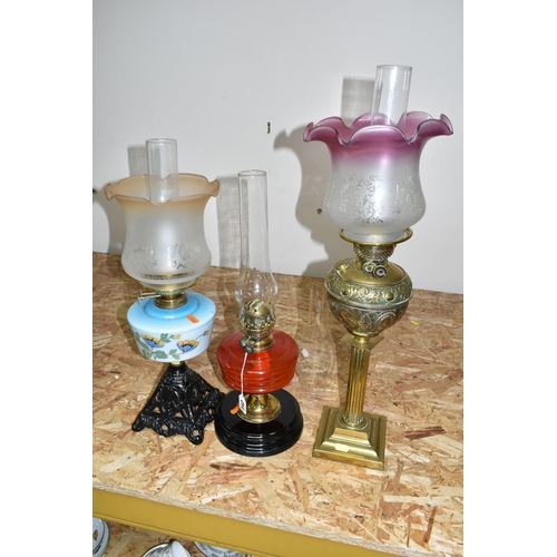 342 - THREE LARGE VICTORIAN OIL LAMPS, comprising a cast pyramid shaped lamp base, with a blue custard gla... 