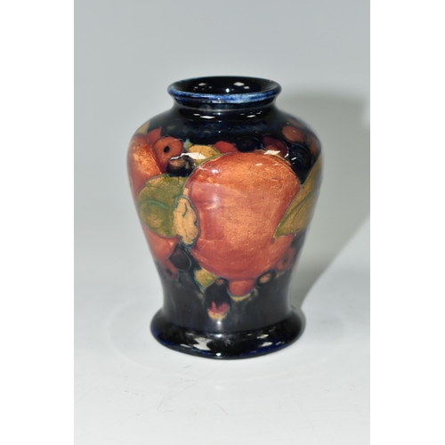 385 - A SMALL MOORCROFT POTTERY 'POMEGRANATE' BALUSTER VASE, with tube lined Pomegranate pattern on a navy... 